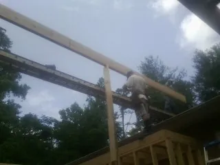 Carpenter setting a ridge beam over a new addition frame — Ice Dam Removal by Roofing Brothers in Milford Square