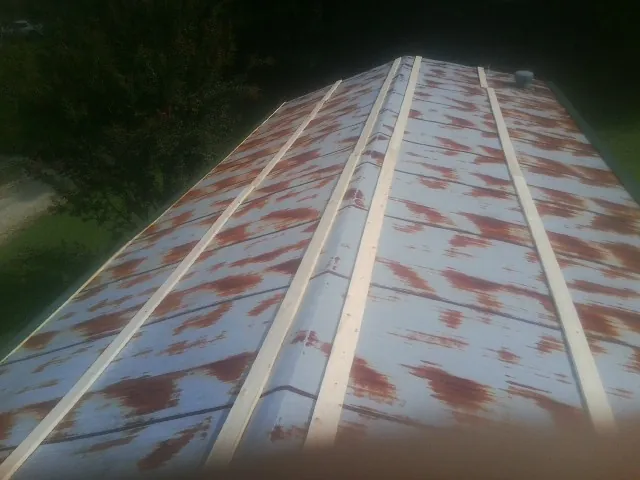 Rusted metal roof panels with new wood purlins before replacement — Storm Damage Roof Repair in Milford Square by Roofing Brothers