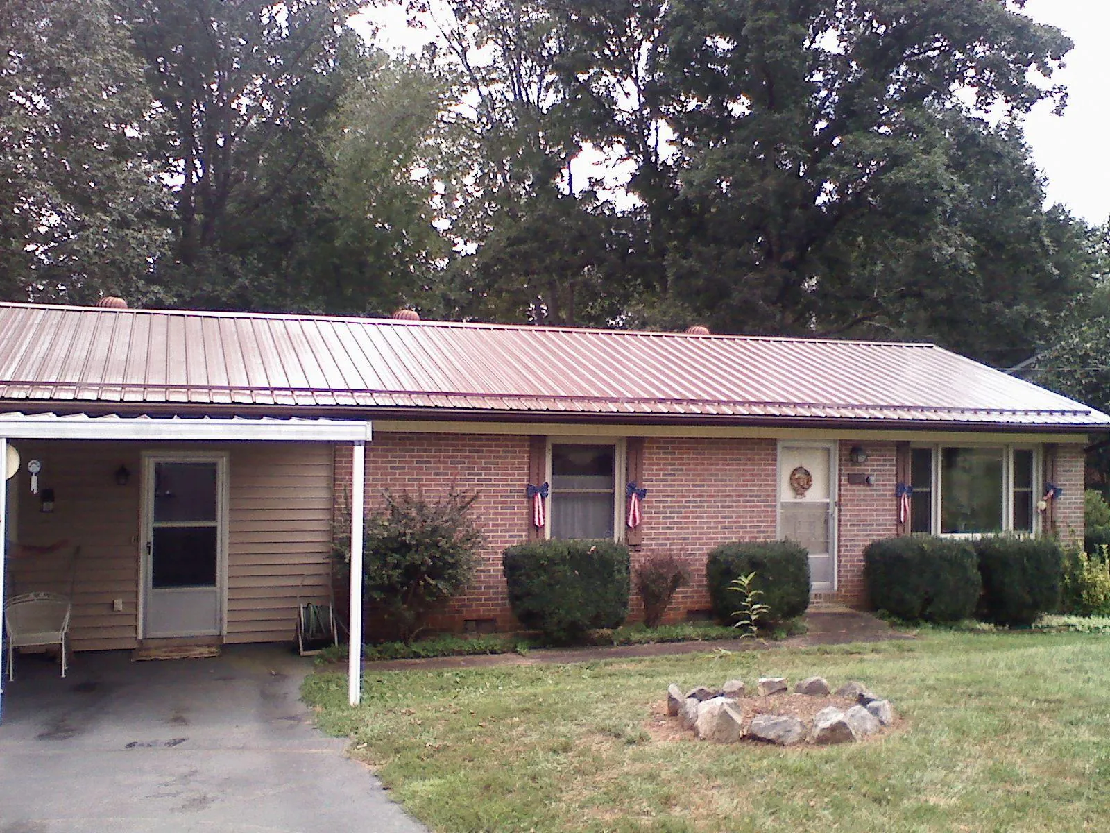 Bronze metal roof and carport on a brick ranch home — Roof Repair work by our crew in Milford Square